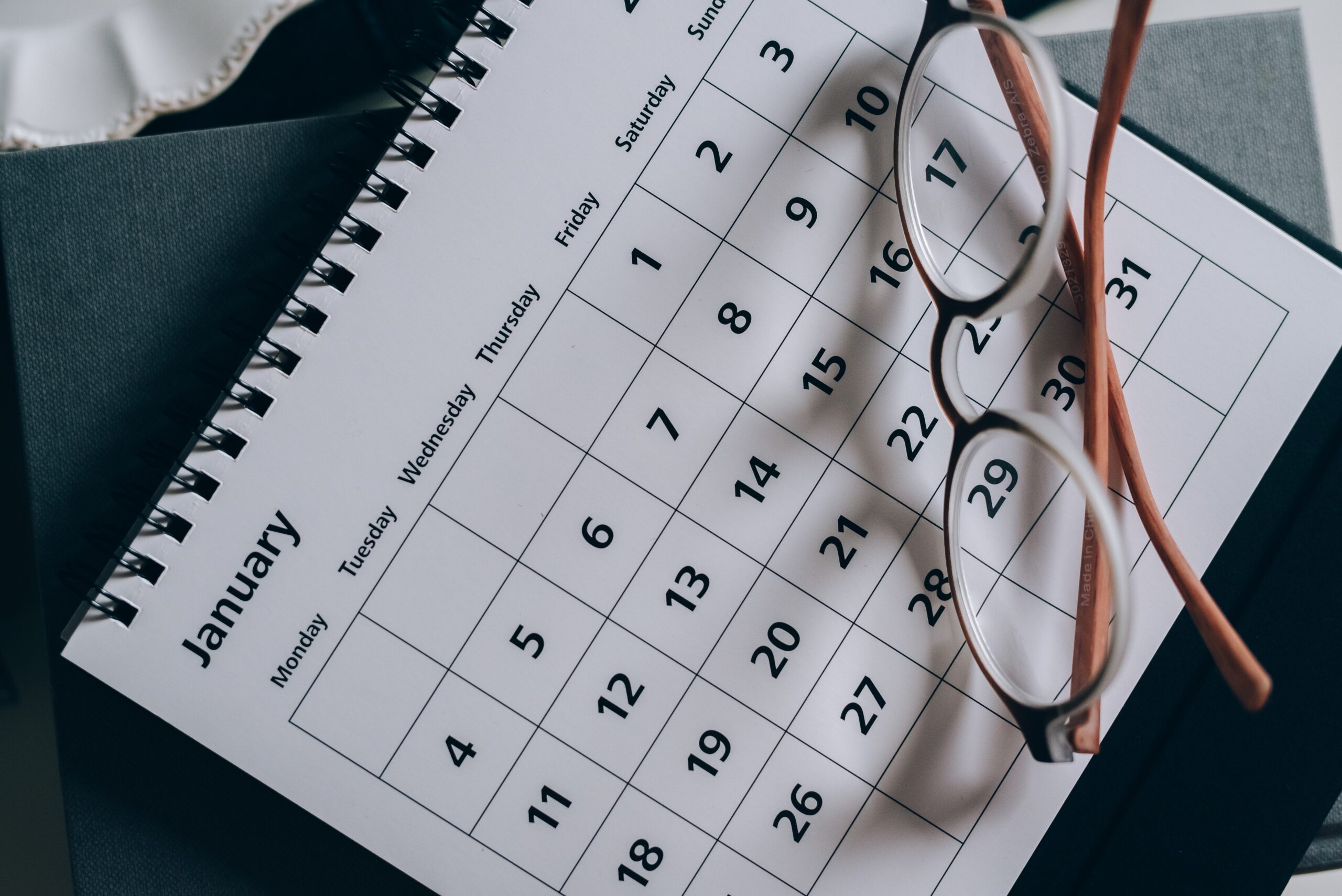 pair of glasses resting on a calendar